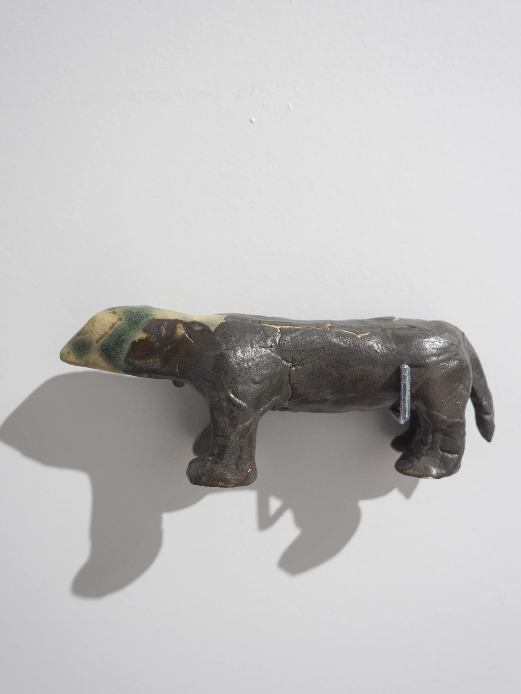 Pequeña escultura cerámica zoomorfa proyectando su sombra