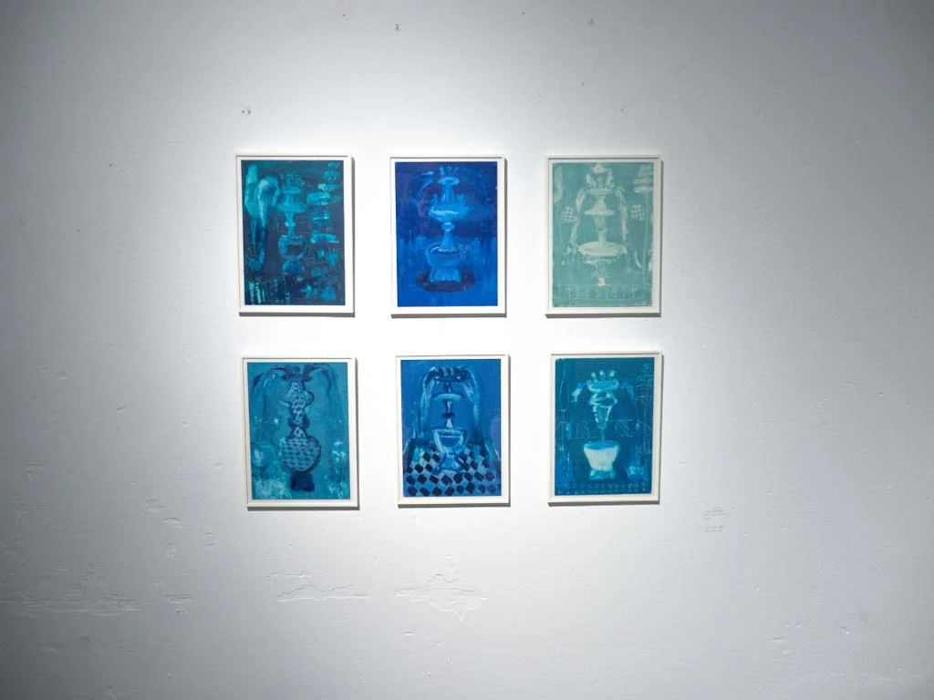 Serie de seis pequeñas obras gráficas azules instalada en pared