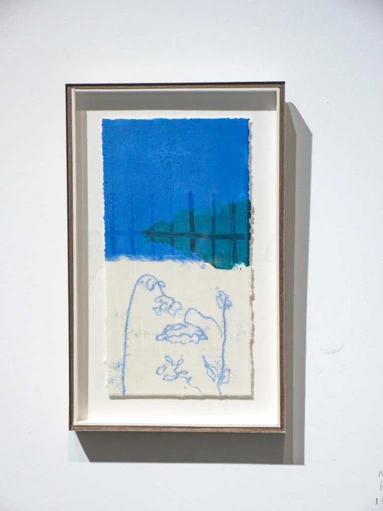 Obra gráfica enmarcada con campo azul y dibujo inferior