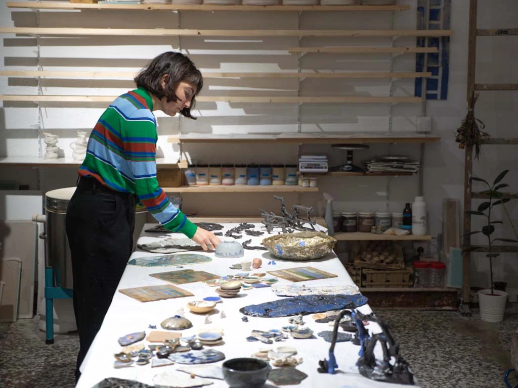 Brenda Ranieri ordenando piezas y muestras sobre la mesa