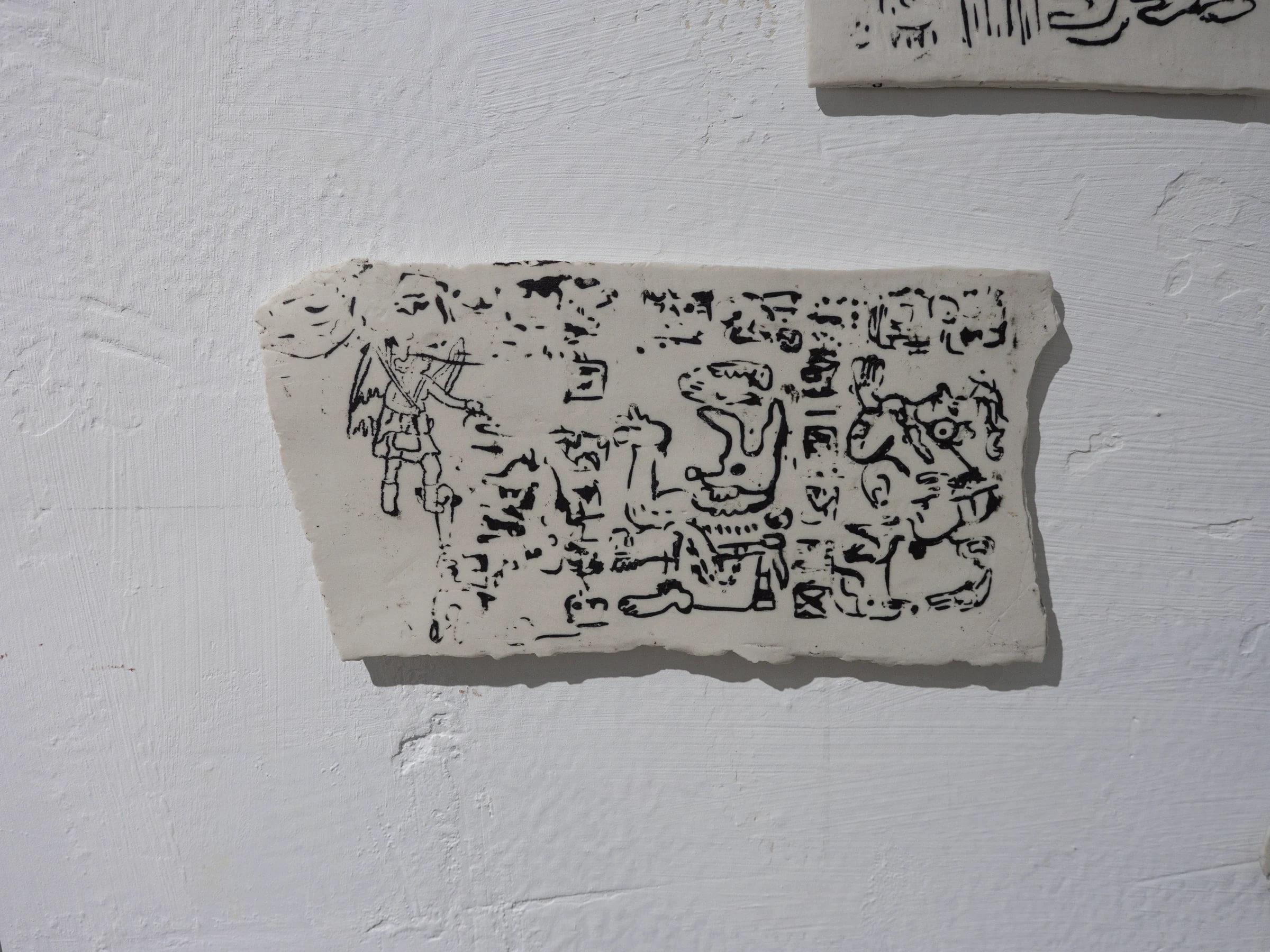 Placa cerámica rectangular con dibujo negro en relieve