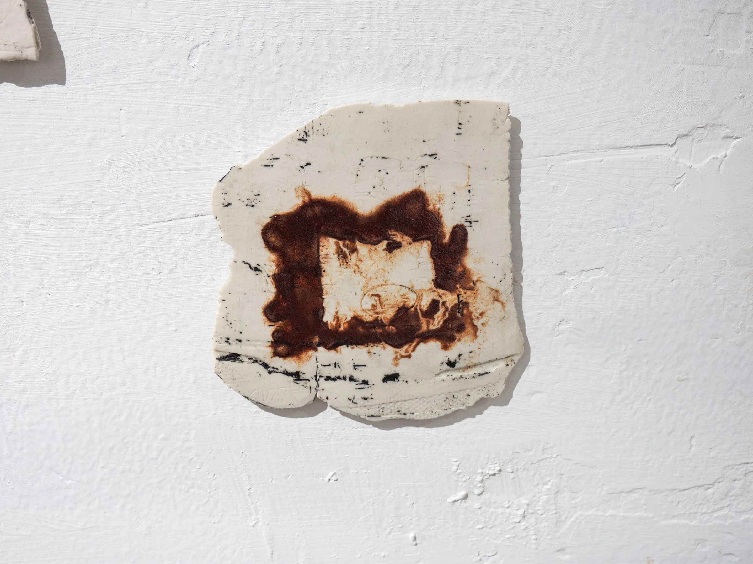Fragmento cerámico blanco con marca circular de óxido