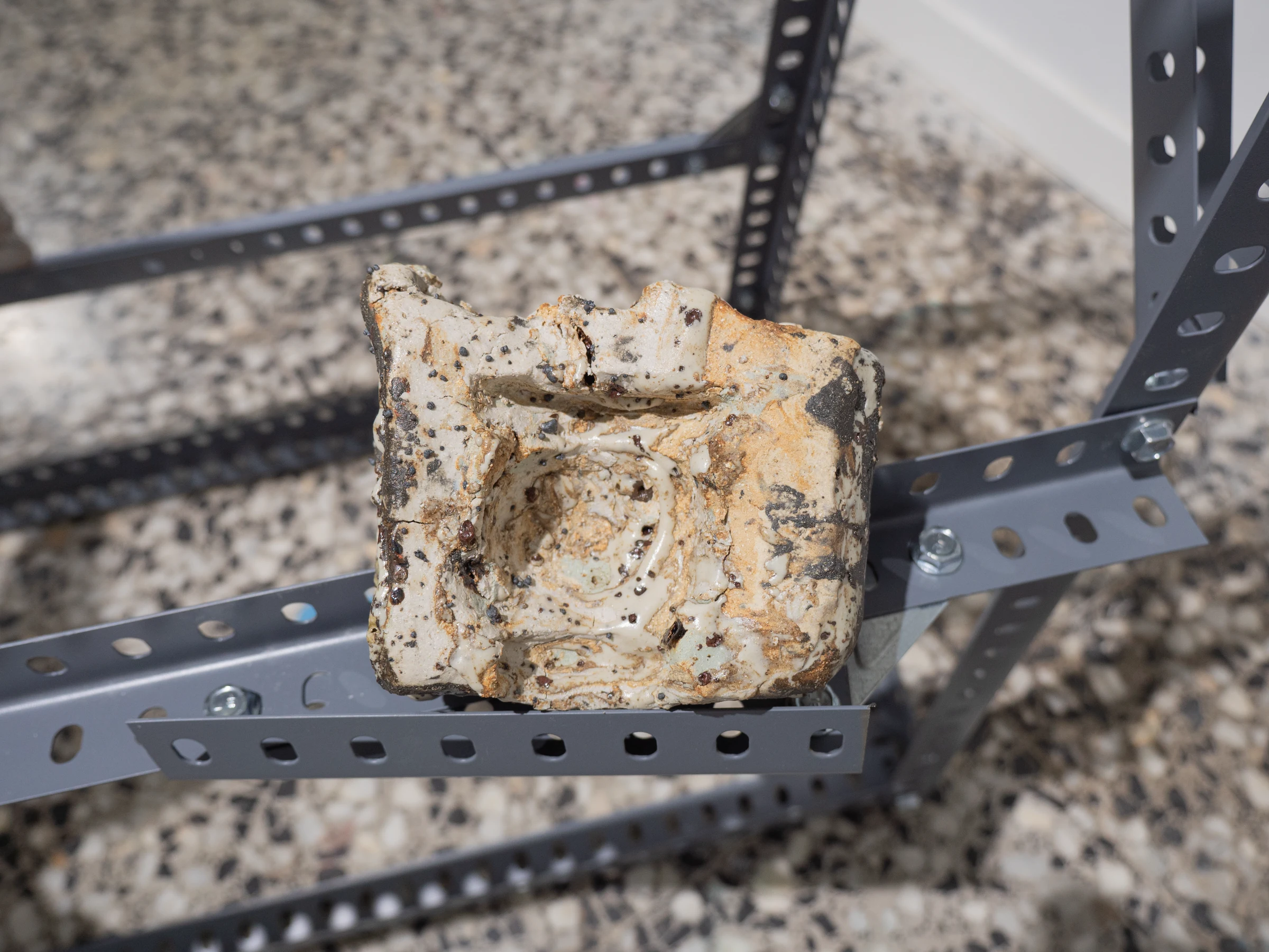 Fragmento cerámico poroso colocado sobre una estructura metálica