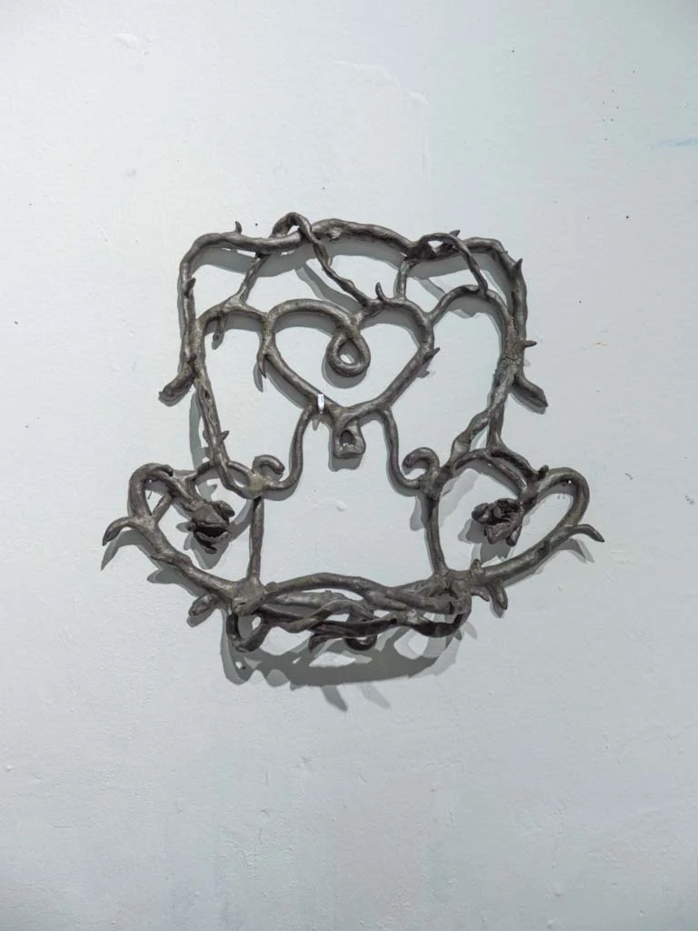 Relieve metálico orgánico suspendido en pared blanca