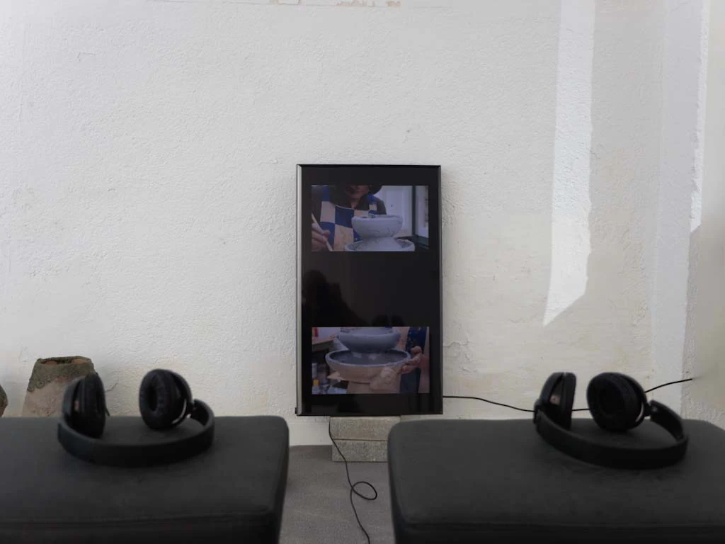 Monitor y pequeñas piezas cerámicas en una mesa de sala