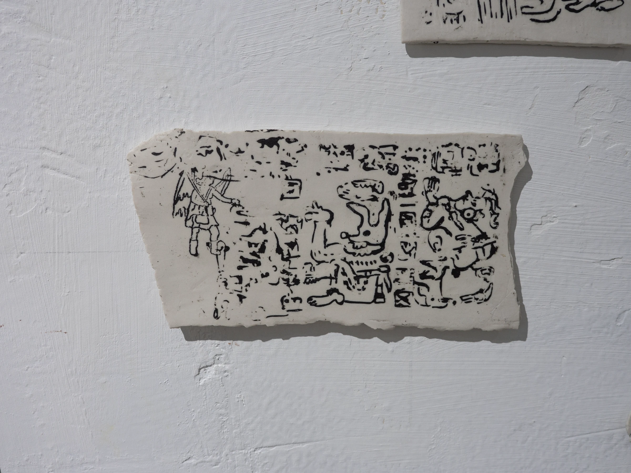 Placa cerámica rectangular con dibujo negro en relieve