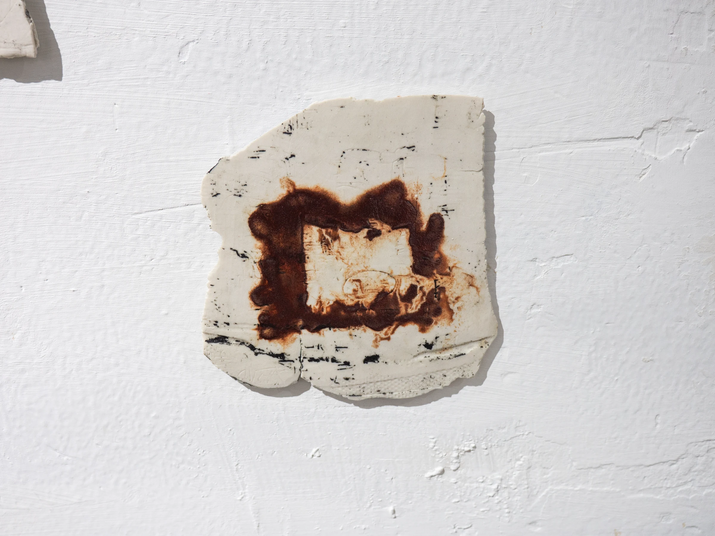Fragmento cerámico blanco con marca circular de óxido