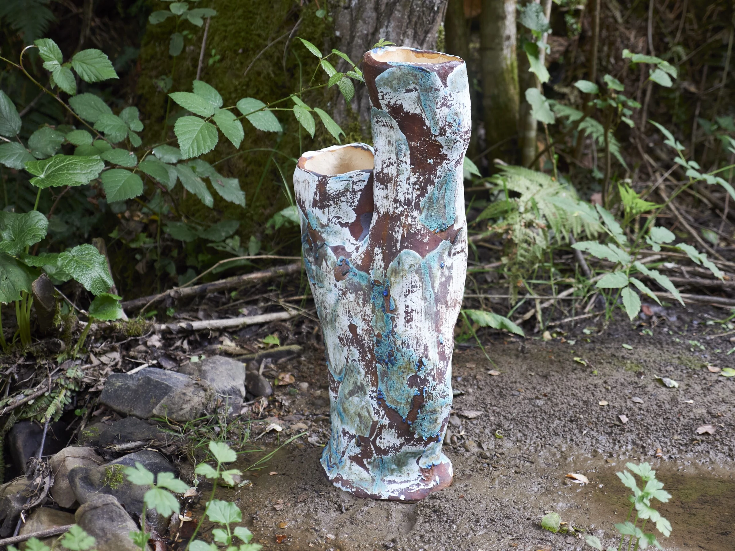 Escultura material integrada en el suelo del bosque